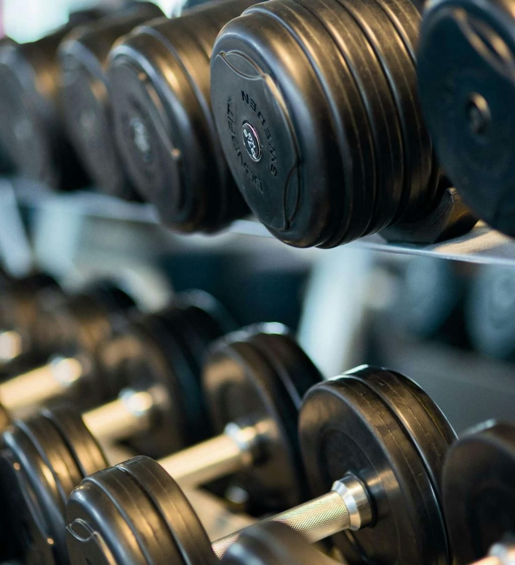 pexels-photo-260352-260352 Close-up view of black dumbbells neatly arranged on a rack in a gym.